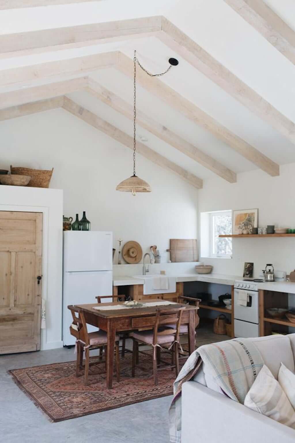 white kitchen with beamed wood ceilings and eat-in wood table kitchen