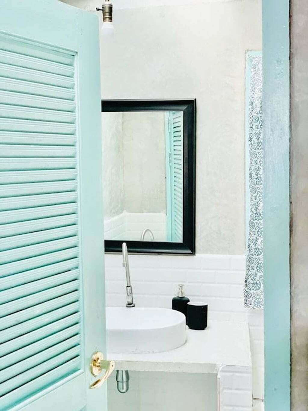 bright blue shuttered doors into beach house bathroom