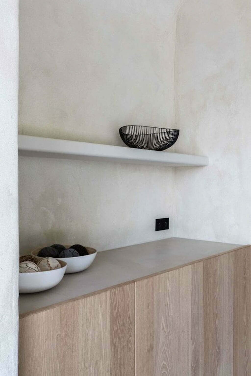 open shelf made of plaster with plaster walls and wood cabinet below