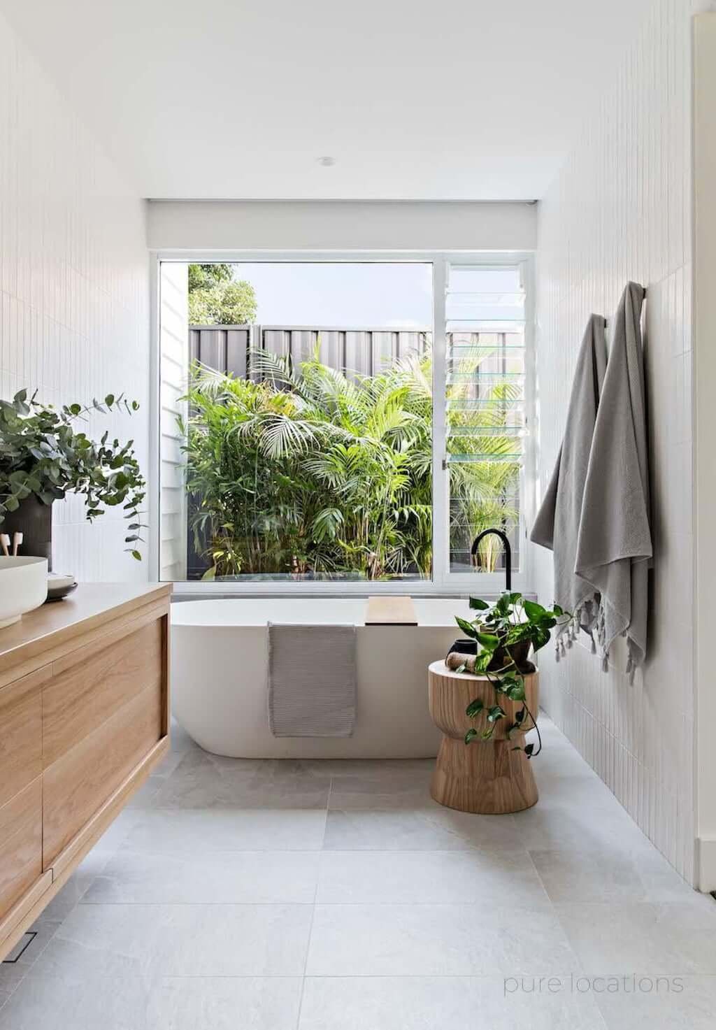 modern beach house bathroom with freestanding tub and wood vanity