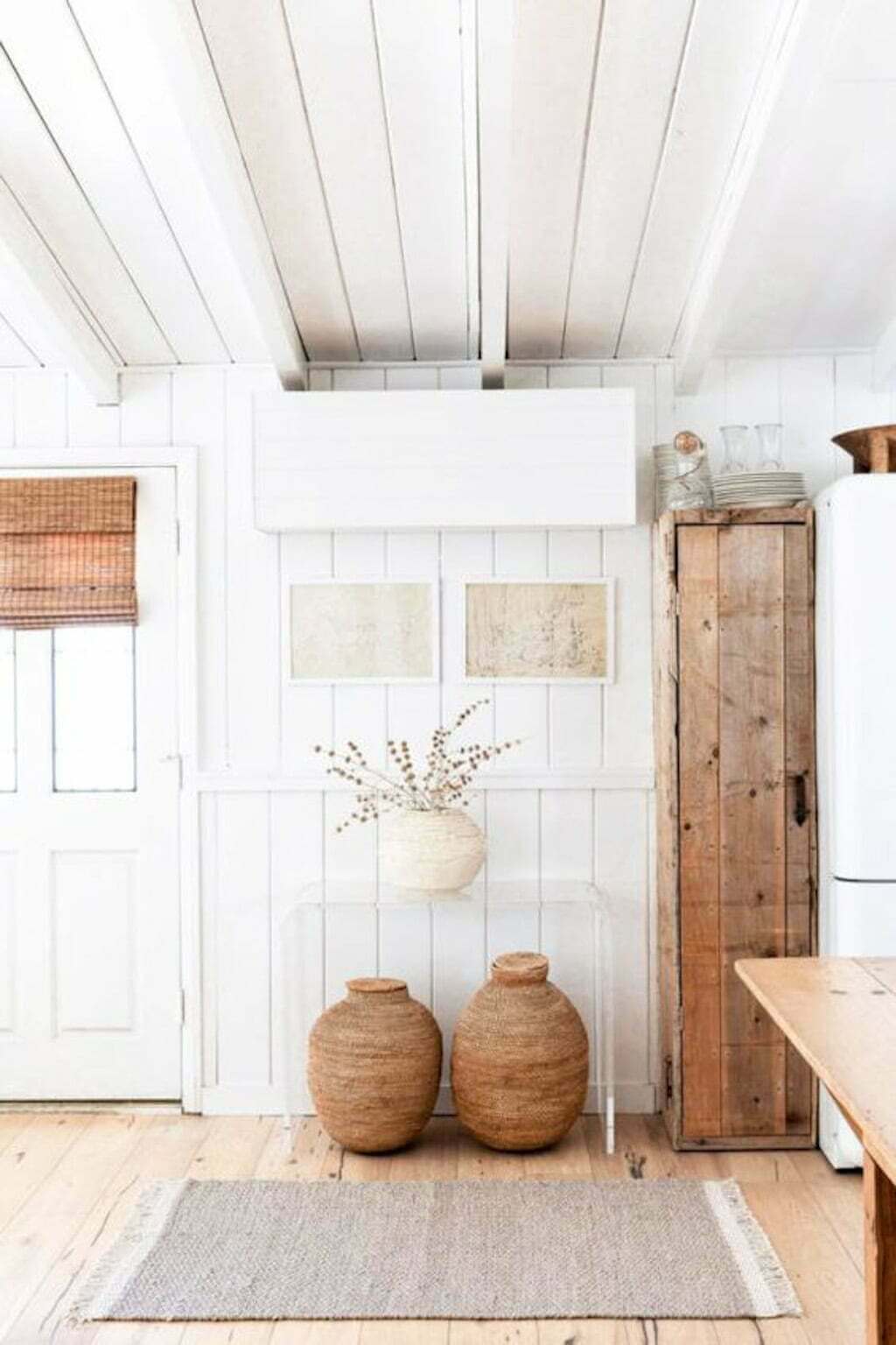 white wood paneled wall with glass console table and baskets