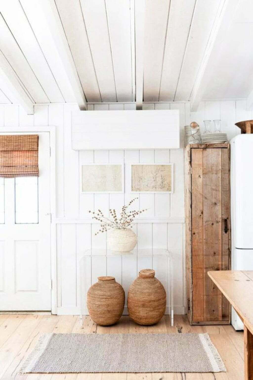 white wood paneled wall with glass console table and baskets