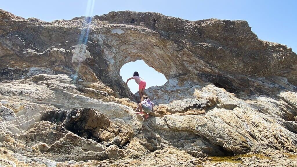 kids climbing up to arched rock near Morro Bay