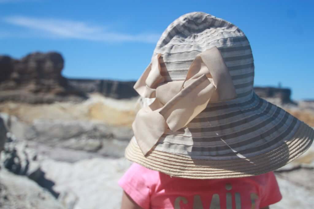 back of little girl's head in striped sunhat