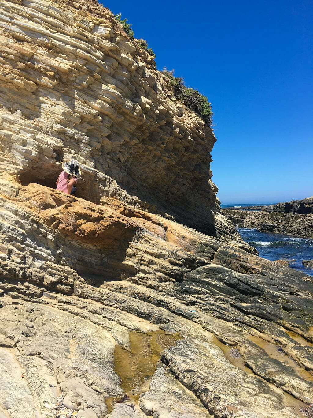 kid climbing on rocks at beach