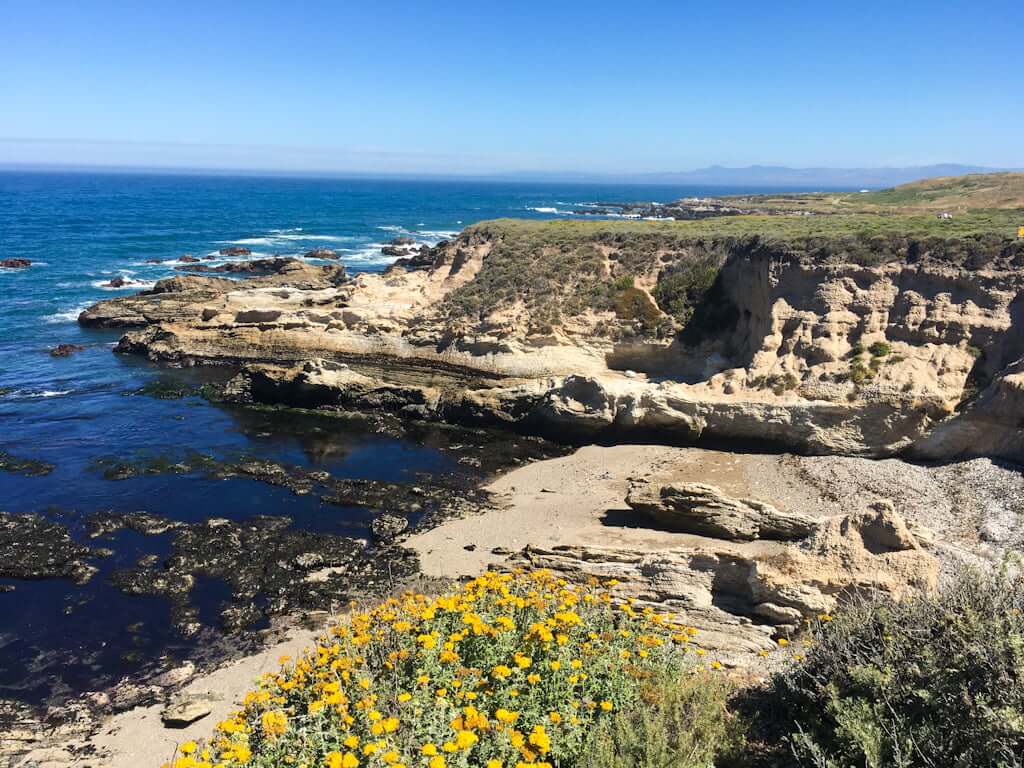 rocky cliffs with beach and ocean below
