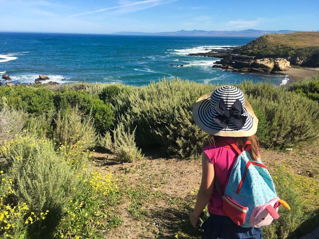 girl looking over Montana de Oro bach and ocean from hilltop