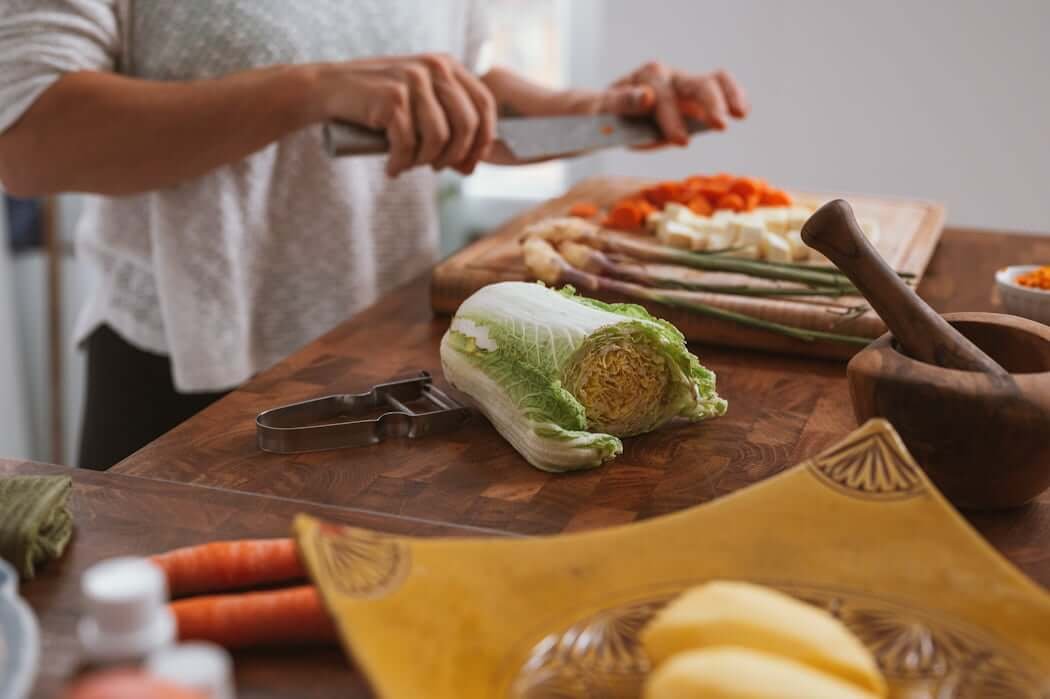 woman chopping vegetables at kitchen counter