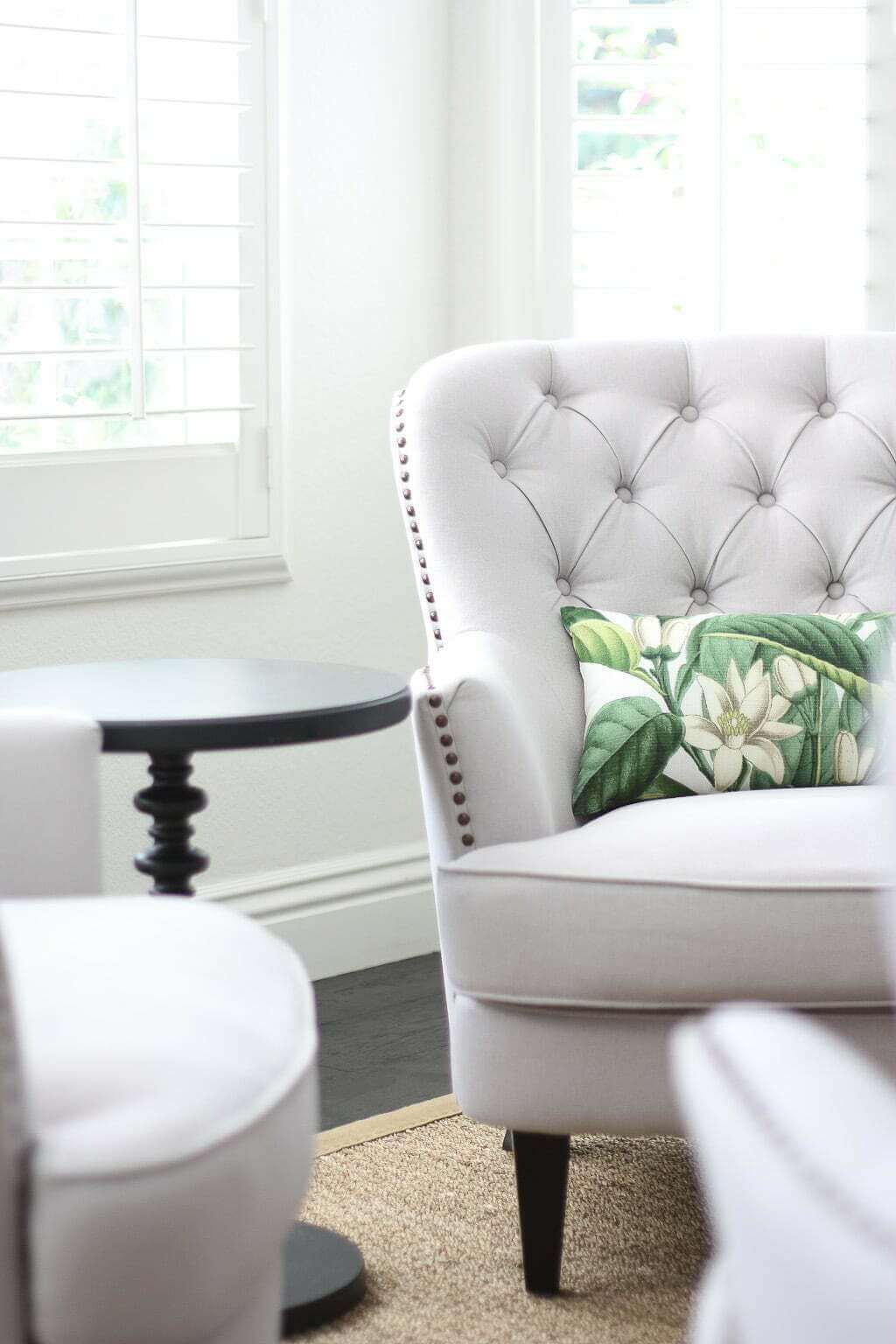 tufted club chair in living room with botanical lumbar pillow