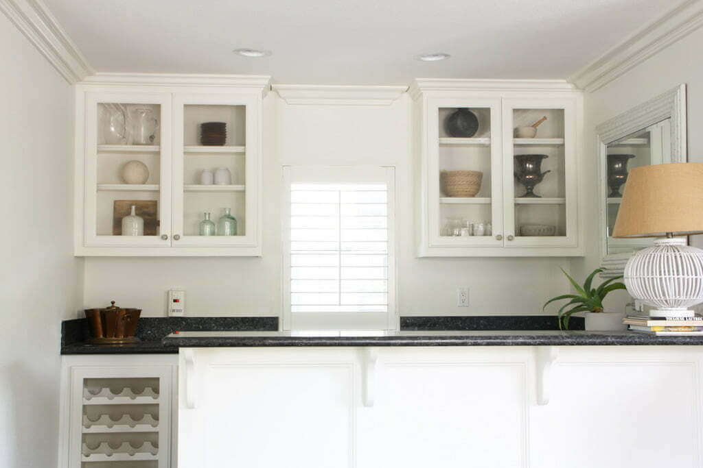 white bar area with glass front cabinets styled