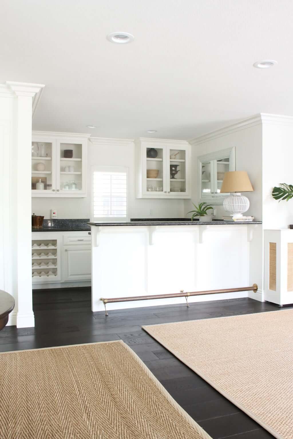 dry bar area with white cabinets off living room