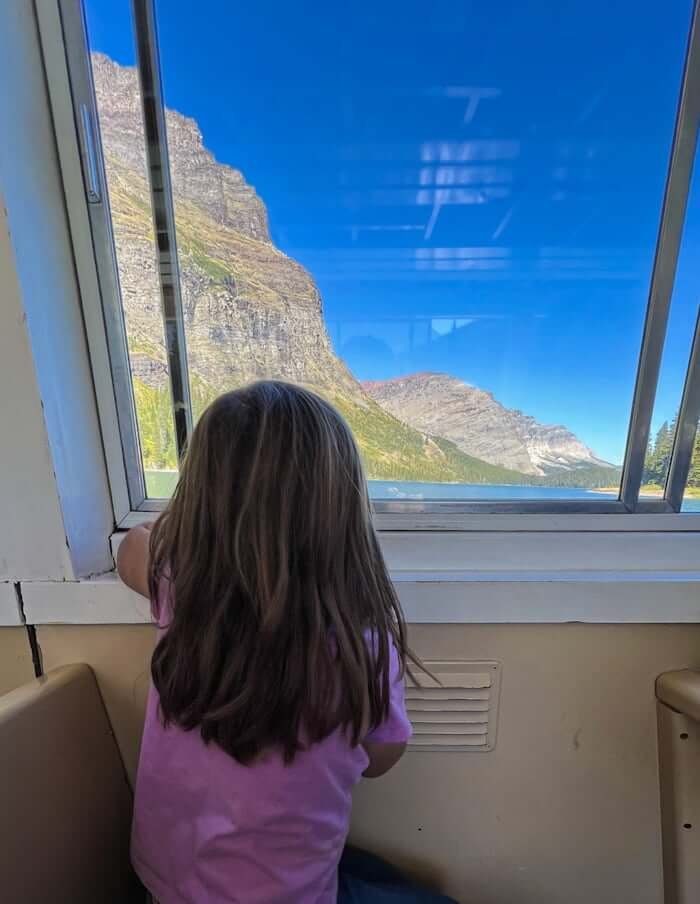 child looking out of window on Many Glacier boat tour