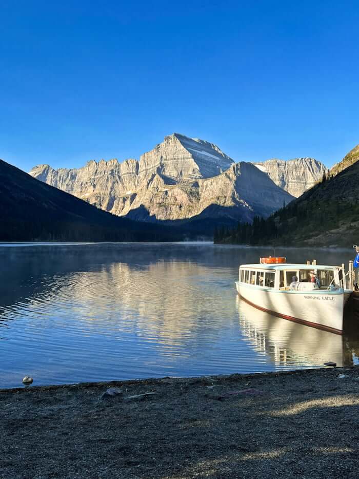boat docked on Lake Josephine in Many Glacier, Montana, with mountains in distance