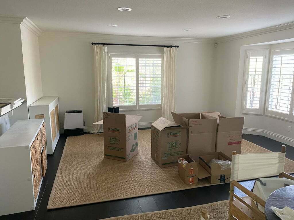 empty living room with seagrass rug and empty boxes