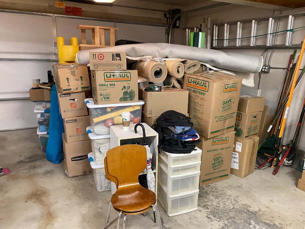 garage filled with boxes and plastic tubs for moving