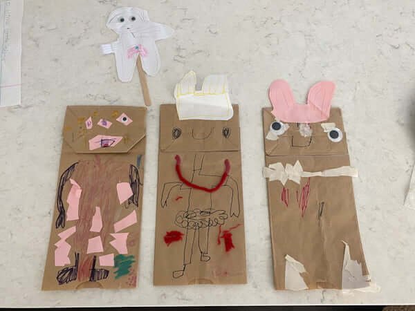 three puppets made by a child out of paper bags