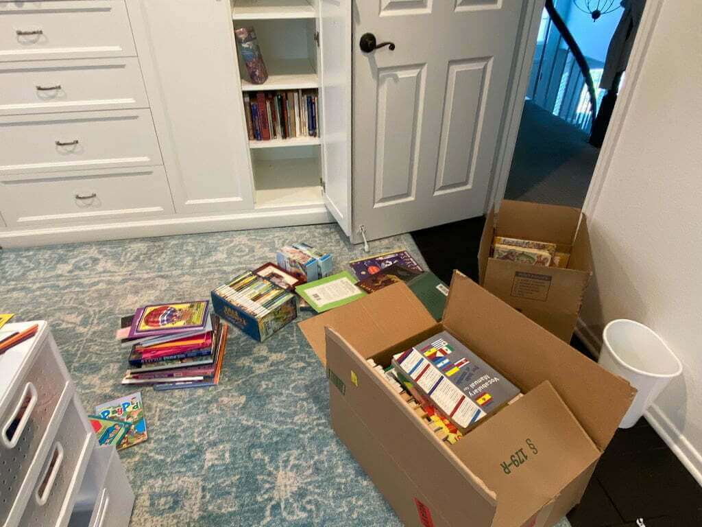 kids room with boxes full of books, rug on floor