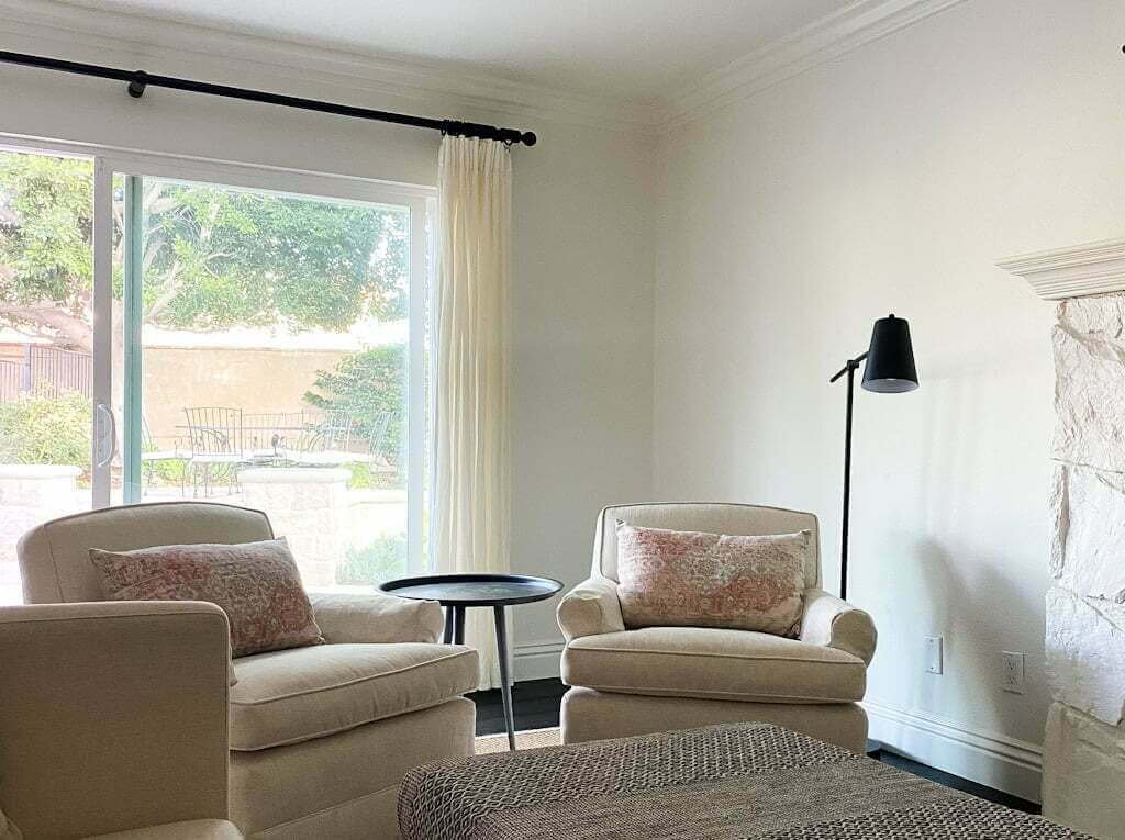 neutral living room with white walls and two armchairs