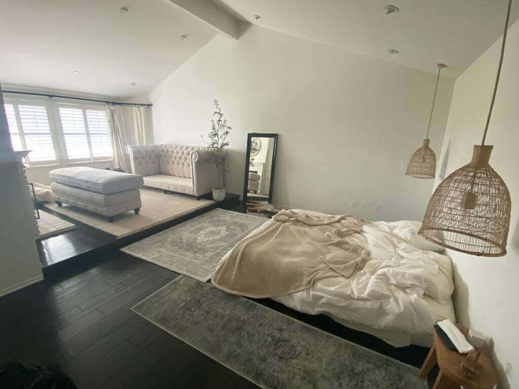 master bedroom with mattress on floor and tufted sofa ready to move