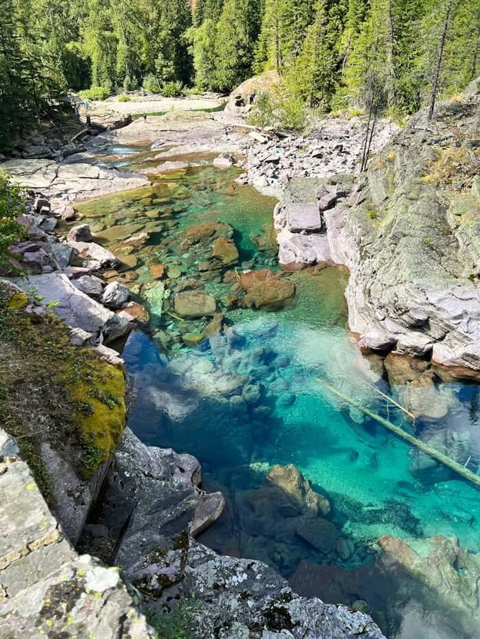 Red Rock Creek with blue water and red rocks below surface