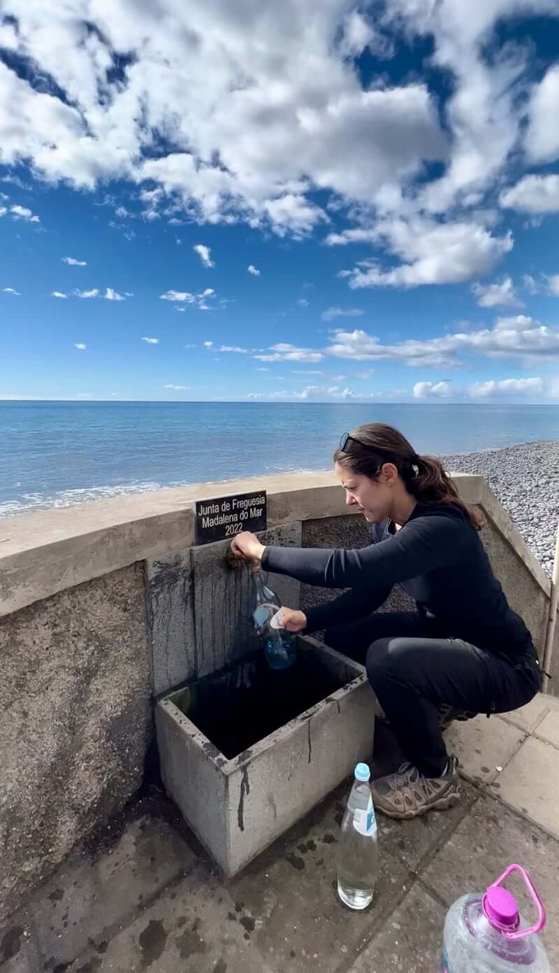 woman filling up water in Madalena do Mar, Portugal