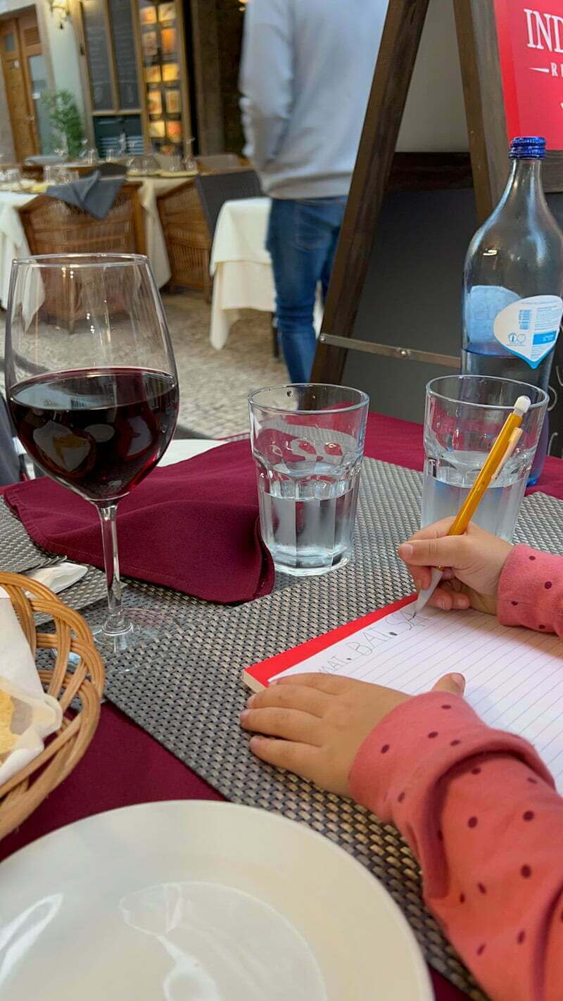 girl writing on dinner table in Funchal, Portugal