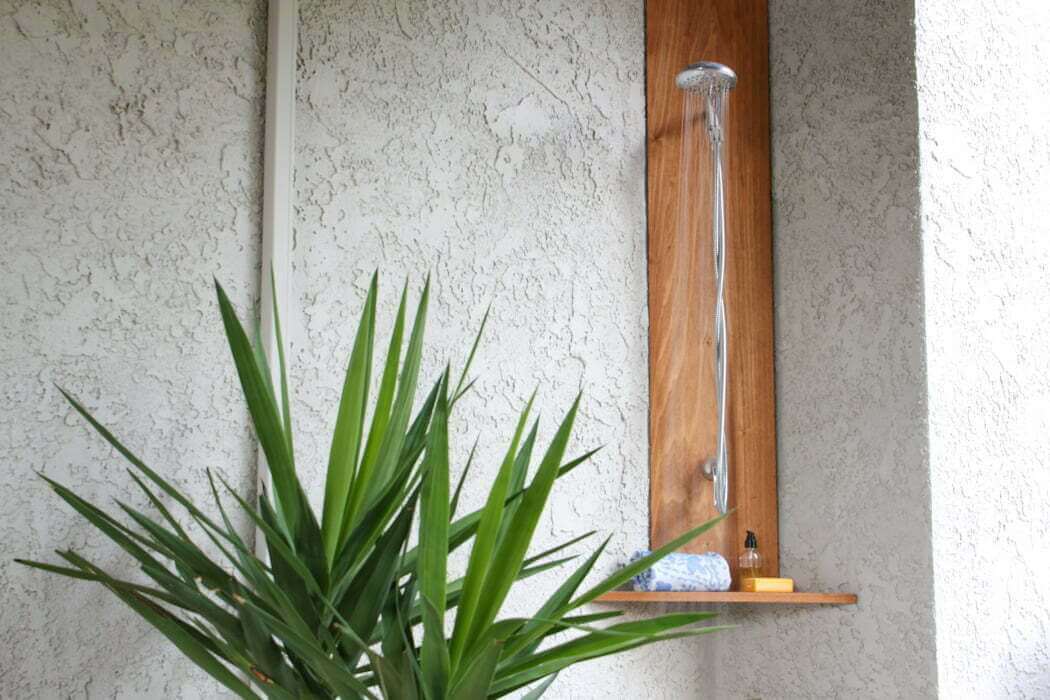 backyard corner with plants showing how to build an outdoor shower