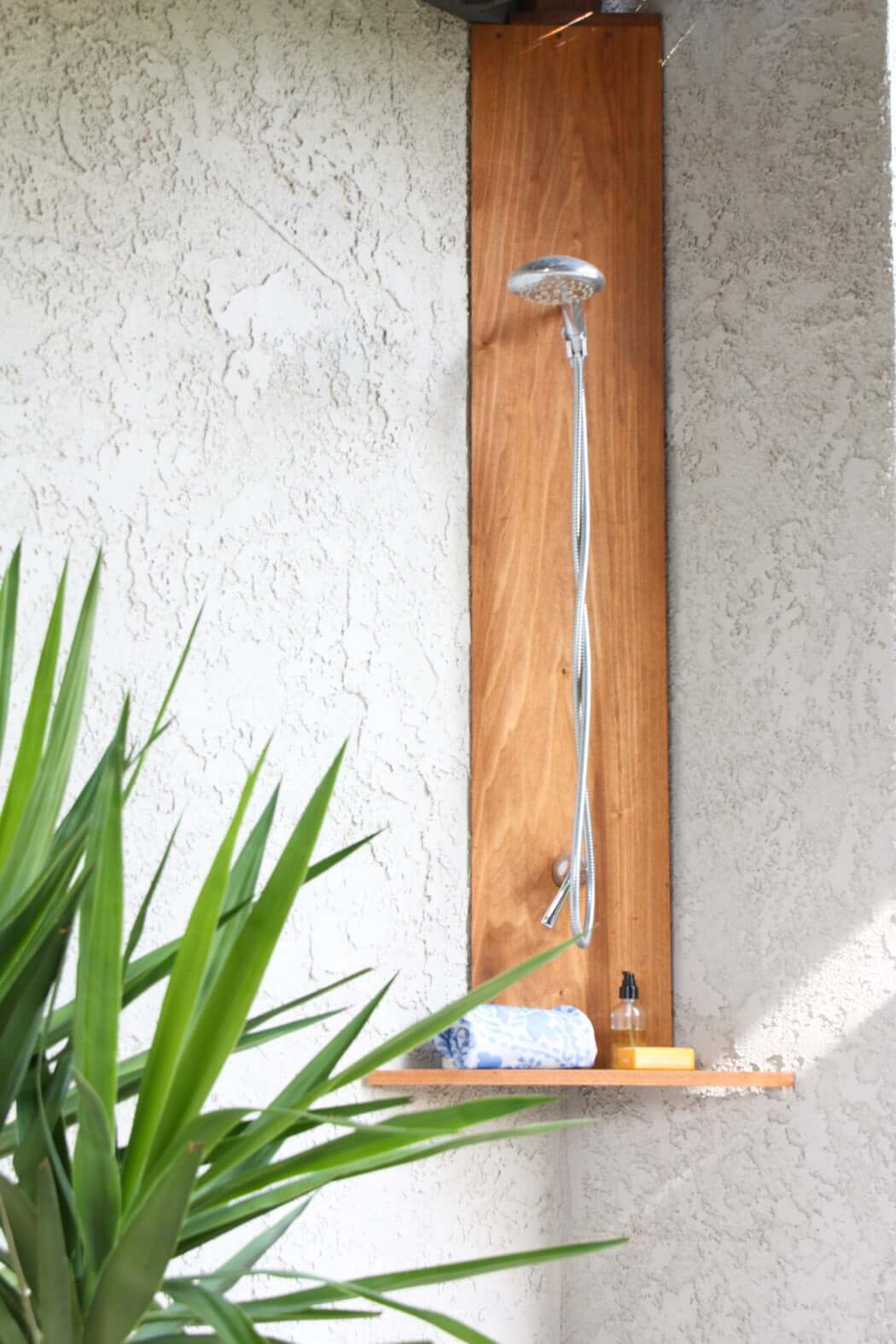 DIY outdoor shower in corner, made of teak and shower fixtures