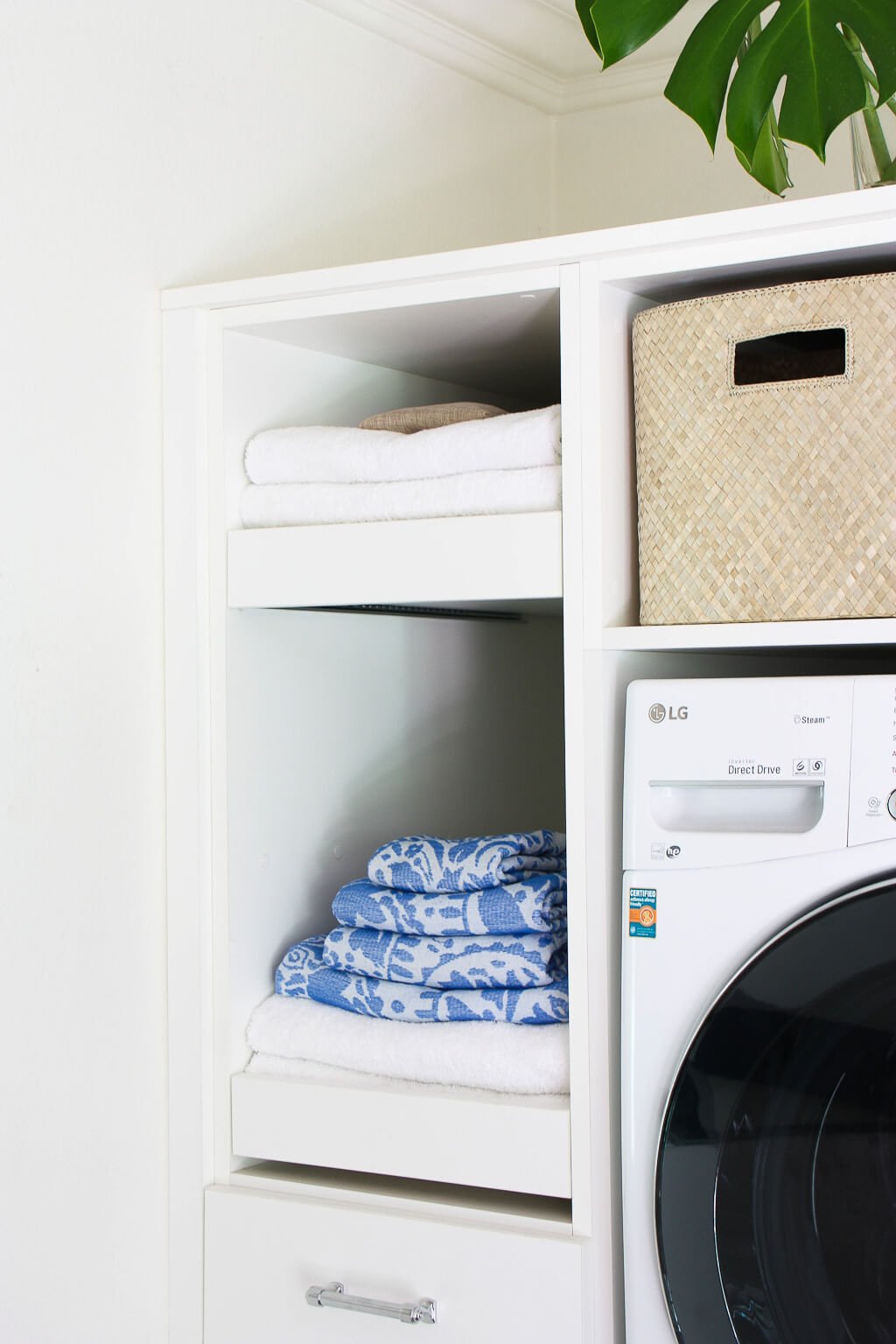 sliding pull-out shelves in laundry room with towels folded