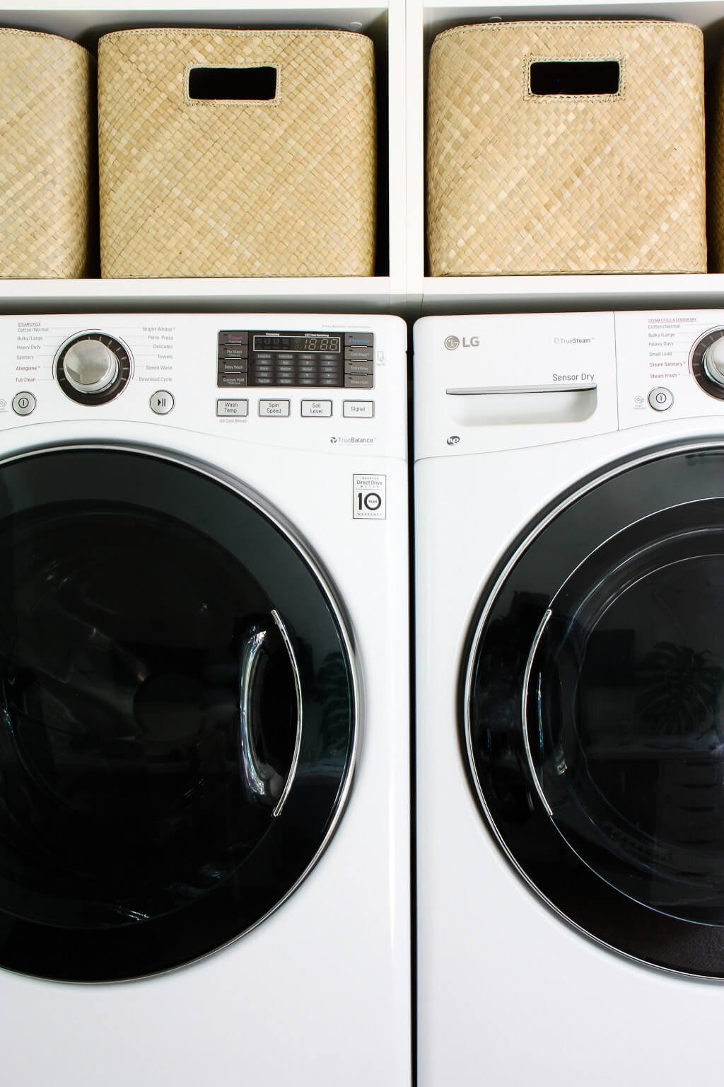 woven laundry baskets above white washer and dryer