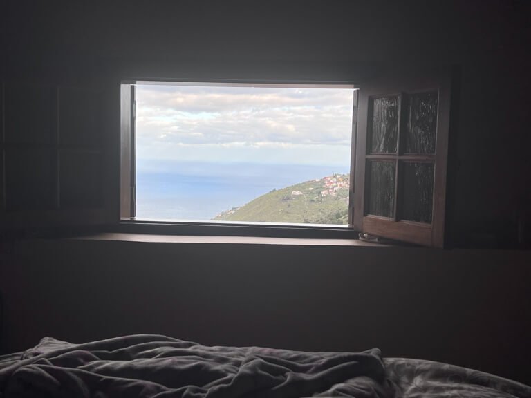 Window with view of mountain with town and ocean