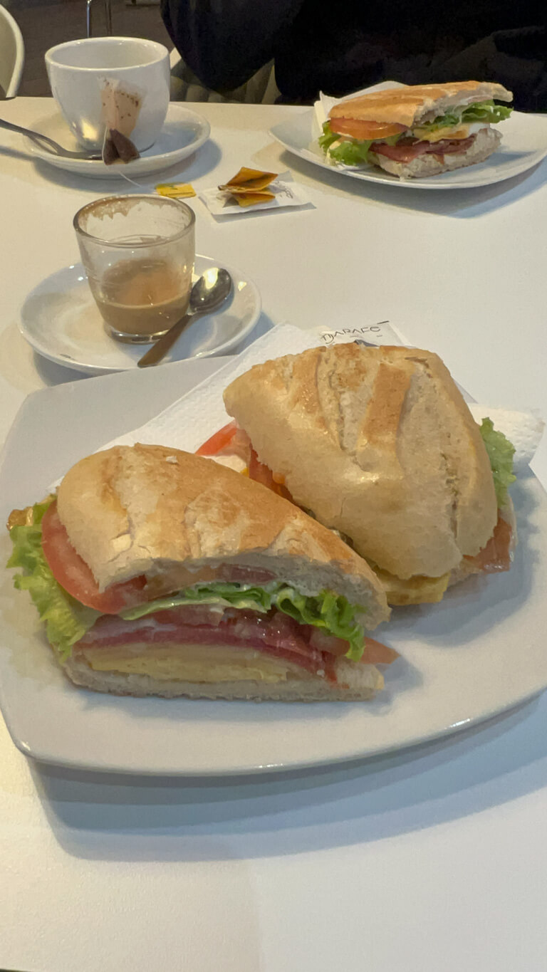 Two bocadillo sandwiches with tea and coffee