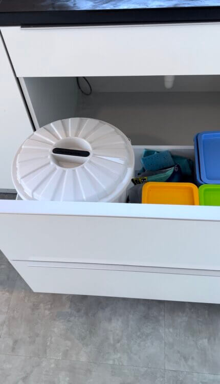 Small under sink trash can drawer. White cabinet. 