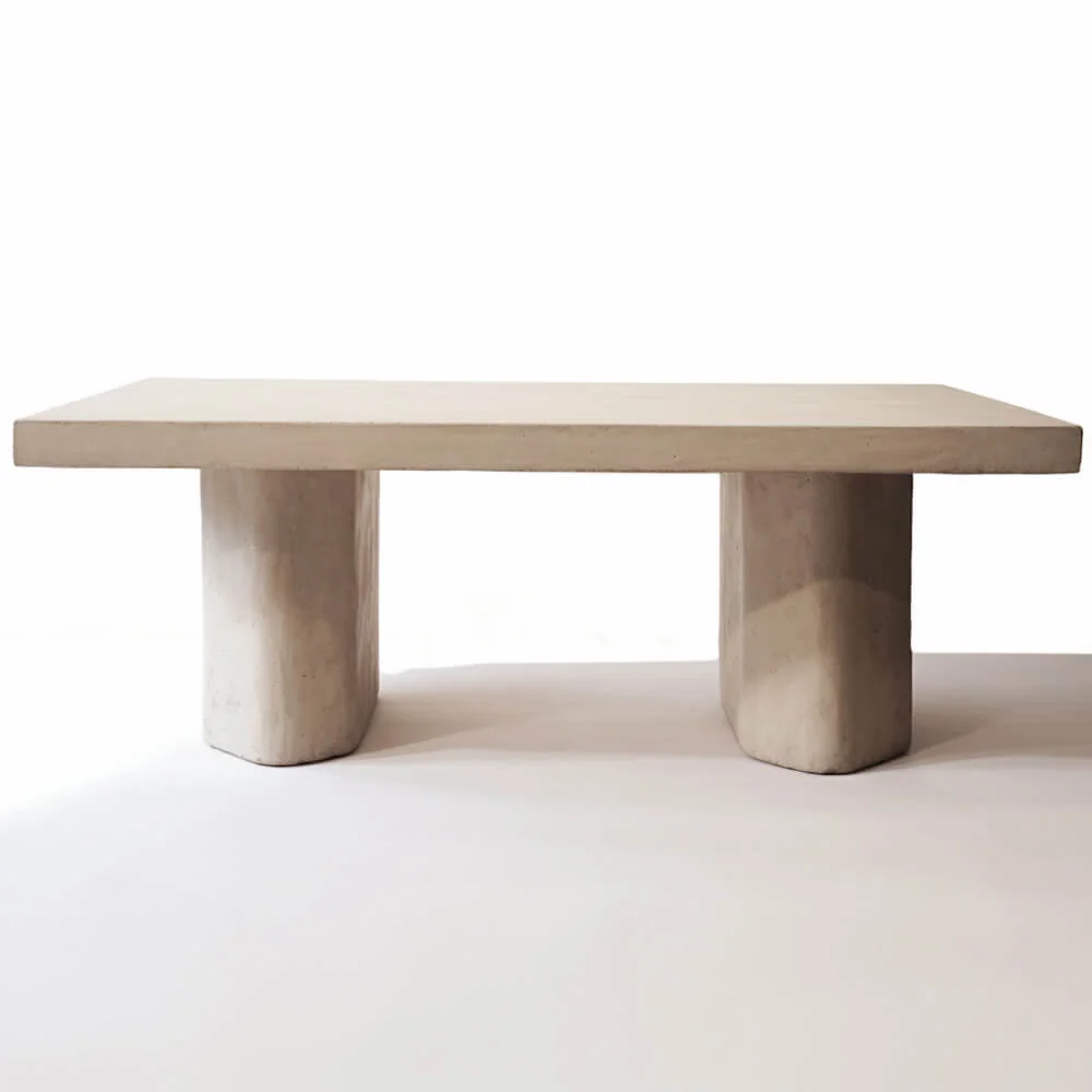 A plaster dining table design with double pedestal base