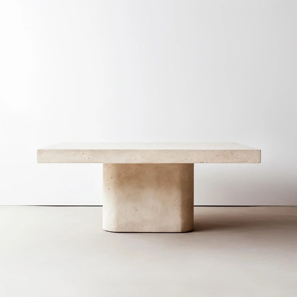 White plaster dining table with singular base and rectangular top