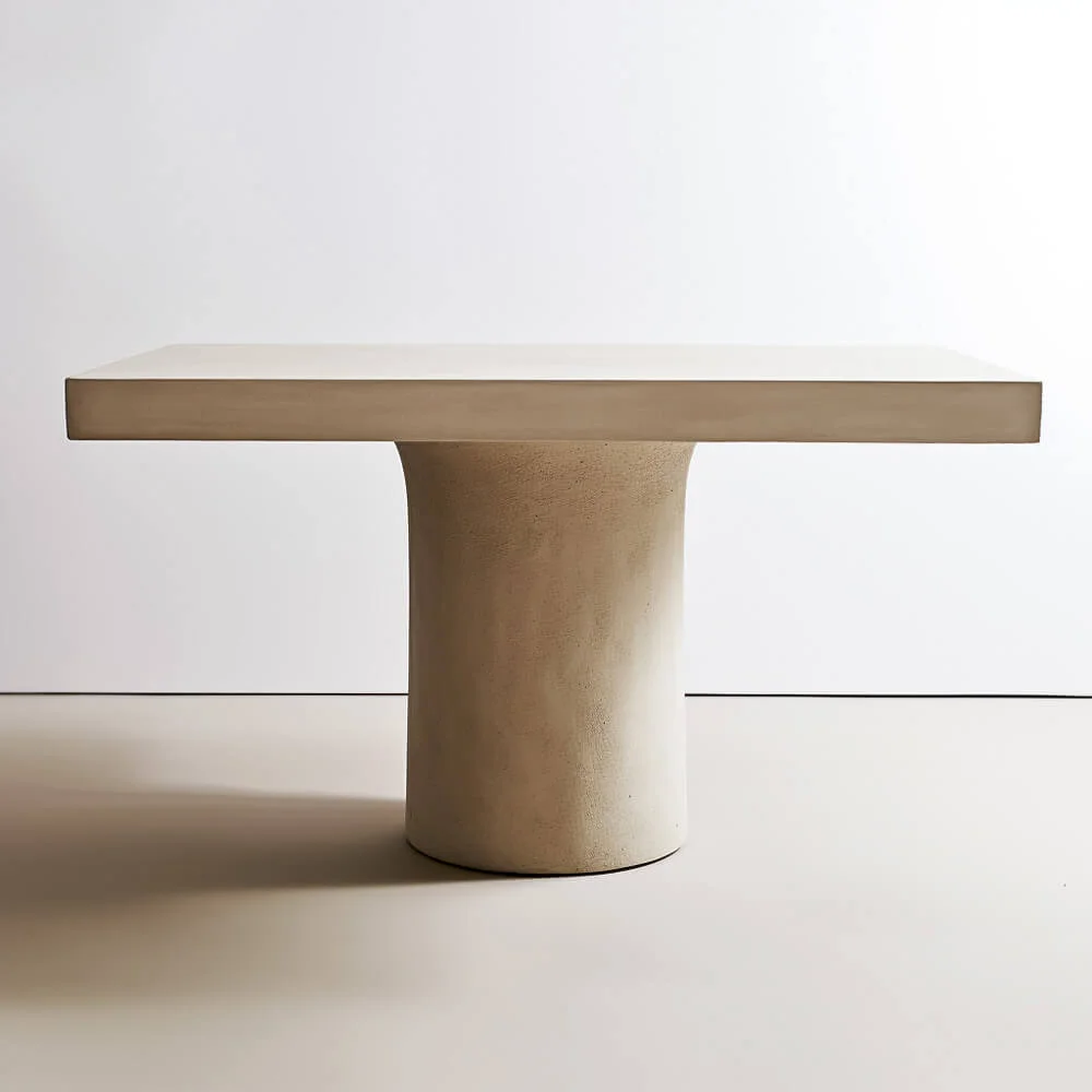 Plaster dining table with a round, textured, singular base and rectangular top