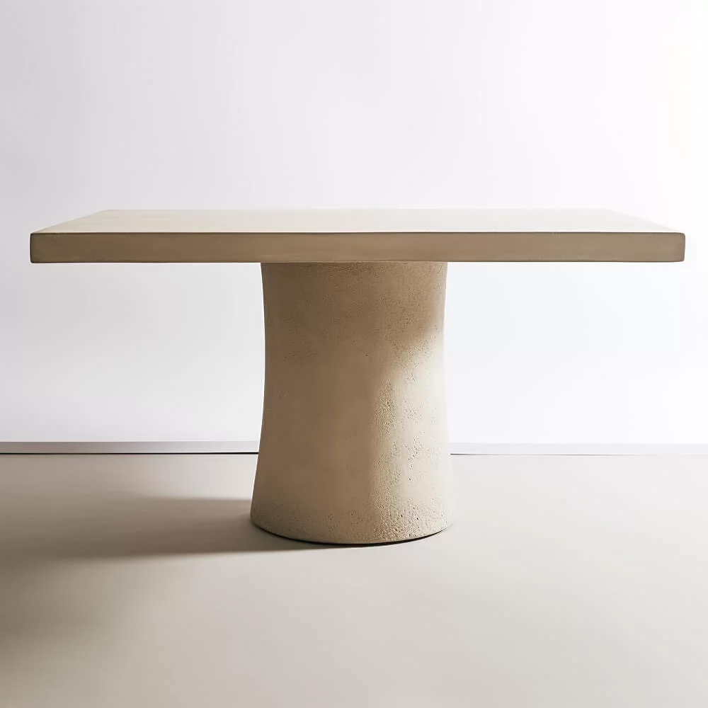 A rectangular dining room table with an organic singular base. 