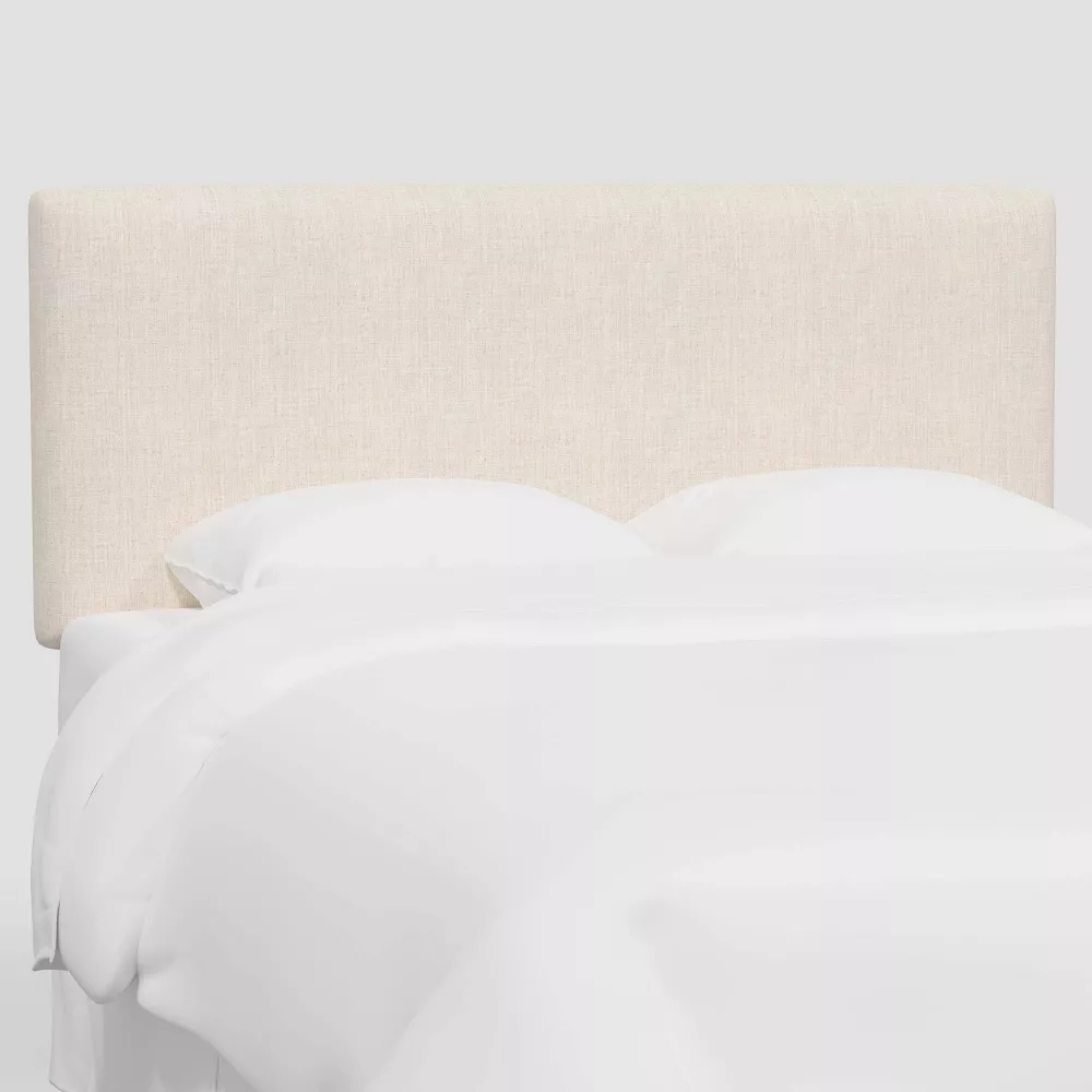 Upholstered linen bed headboard with white bedding
