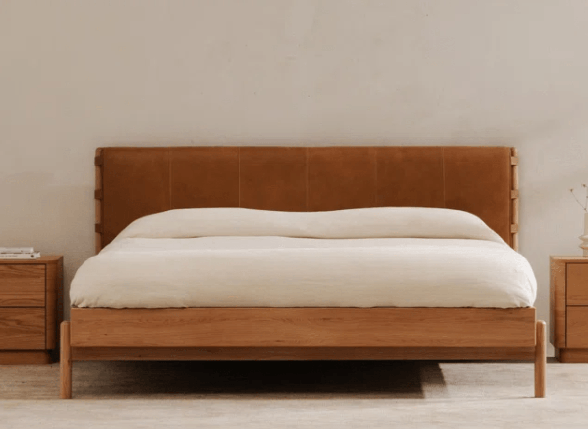 Leather and wood bed frame design with white bedding.