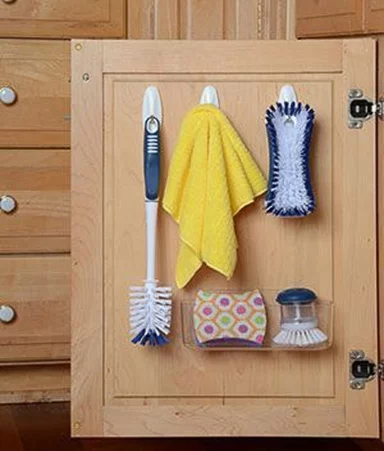 under sink cabinet with command hooks on the back of cabinet door holding dish towels and sponges