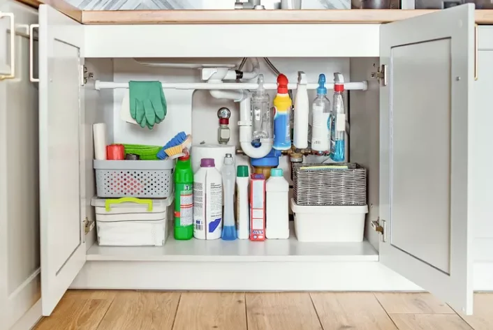 Under kitchen sink storage ideas utilizing a tension rod and baskets