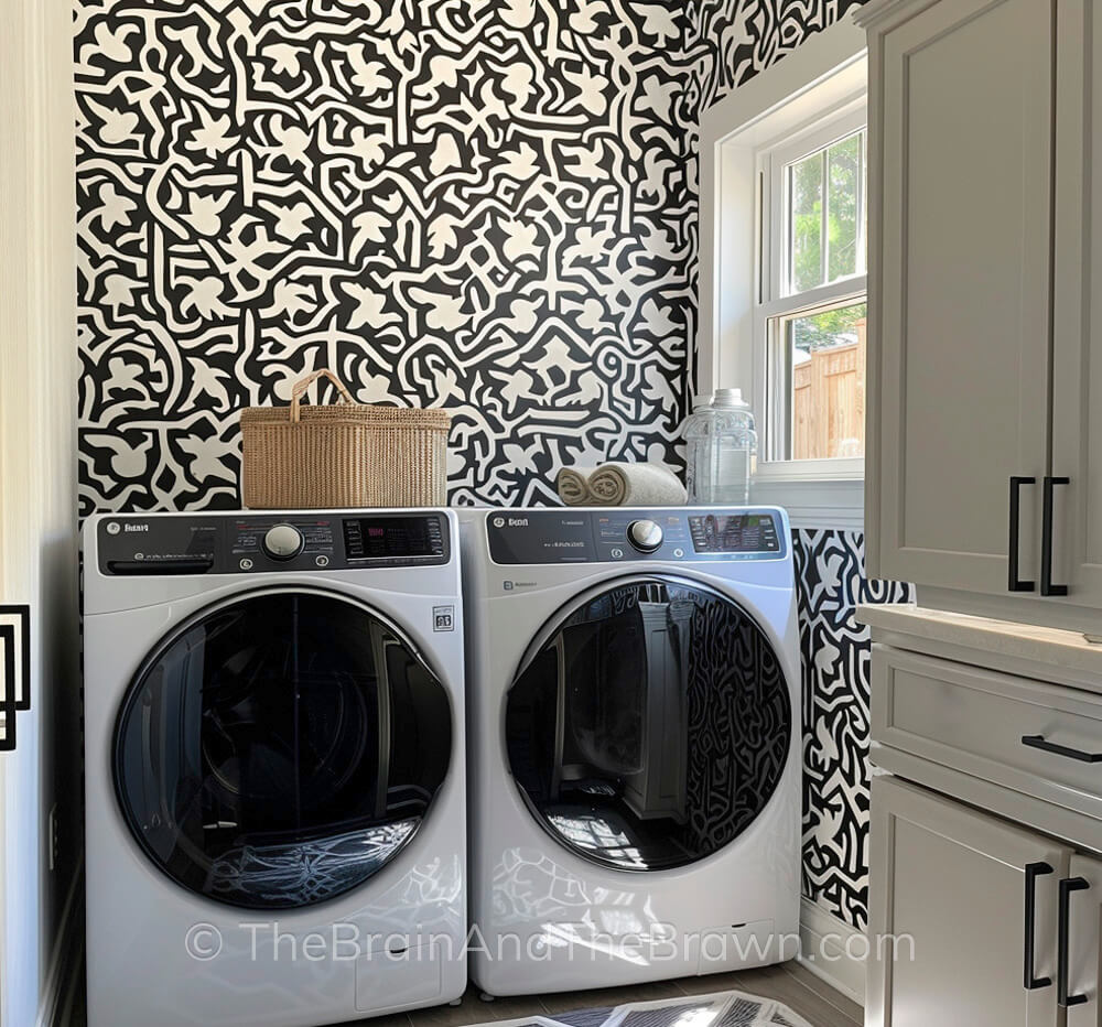 Small laundry room decor idea with wall stenciling. A wicker basket sits on top of the washer and dryer.