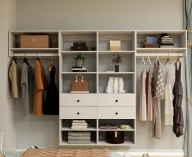 A white closet system with shelves, a space for hanging clothes and a few drawers in the middle.