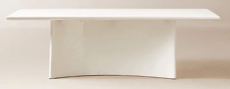 A white plaster dining table with a rectangular table top and rounded, rectangular single base 