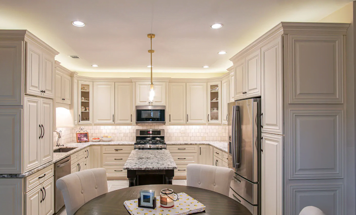 Kitchen with cream kitchen cabinets, black hardware and a black kitchen island