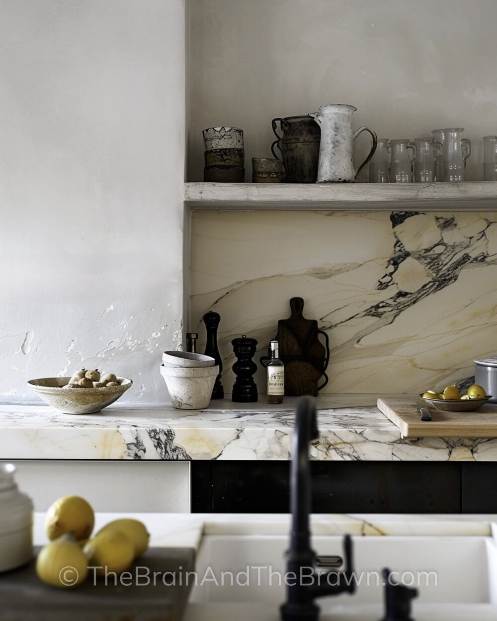 Kitchen with European style kitchen backsplash shelves and white countertops with black veining