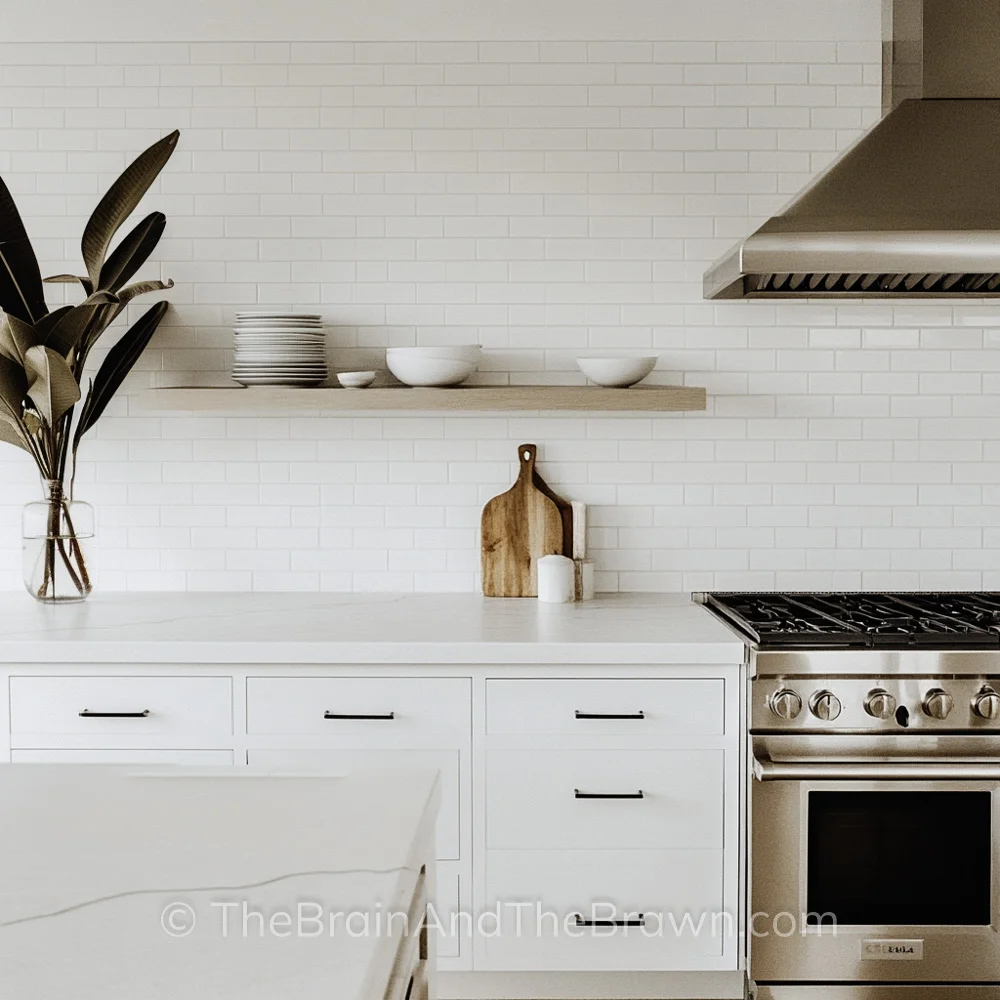 Kitchen backsplash with white cabinets, black hardware and wood floating shelf