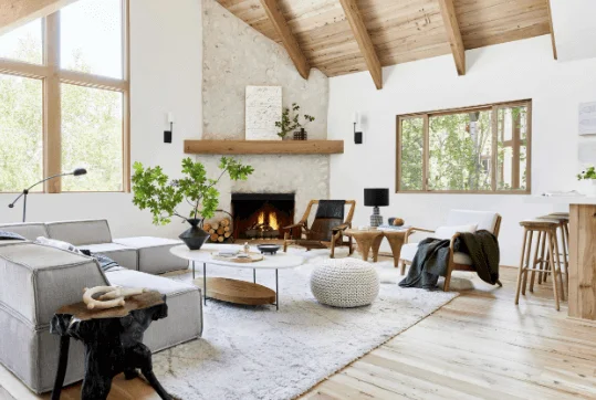 A large living room layout with corner fireplace. A sectional couch is in one corner of the room with two chairs facing the sectional couch. 