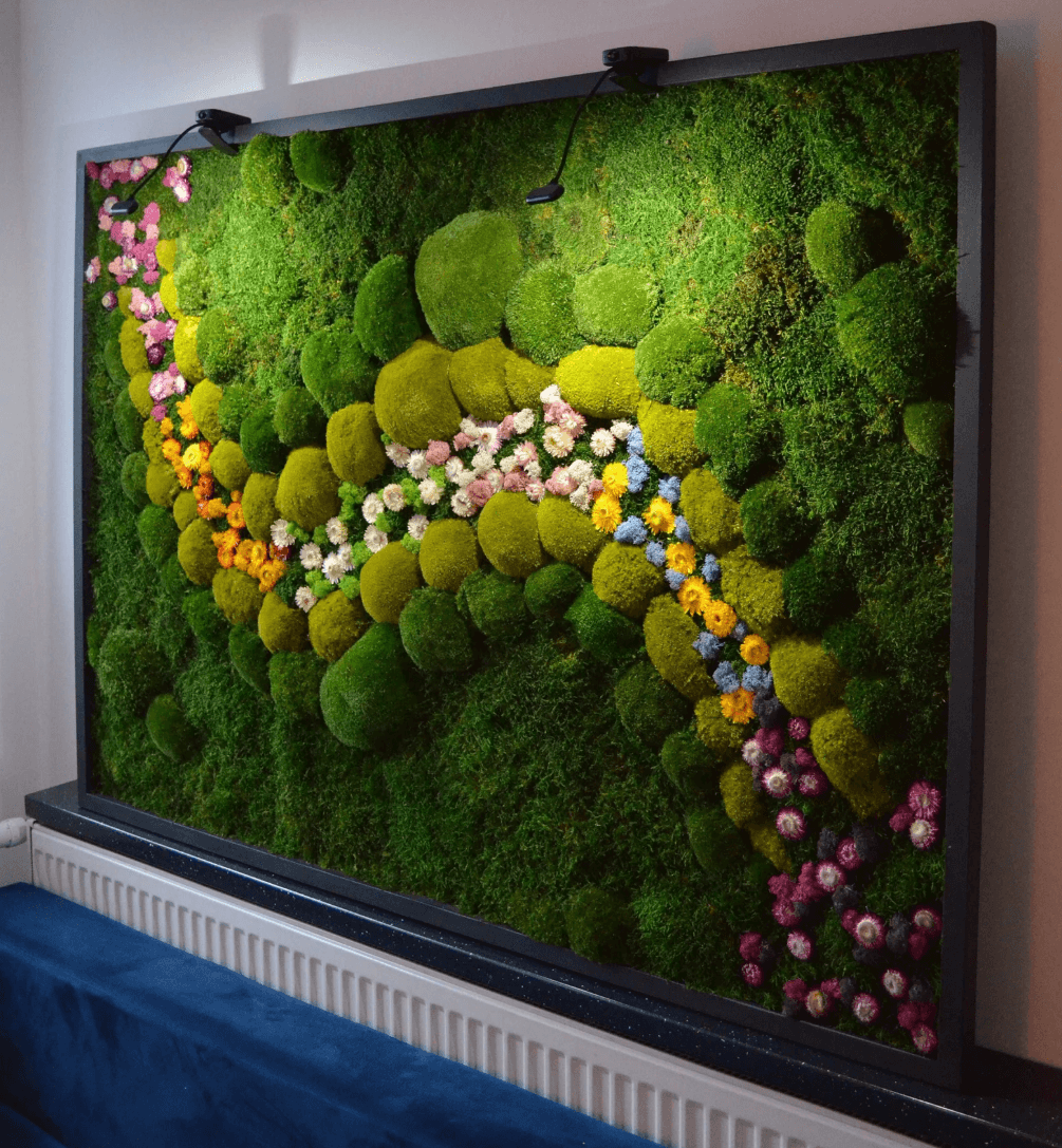 Moss wall art idea with different shades of green moss and blue, yellow, and purple moss down the middle of it 