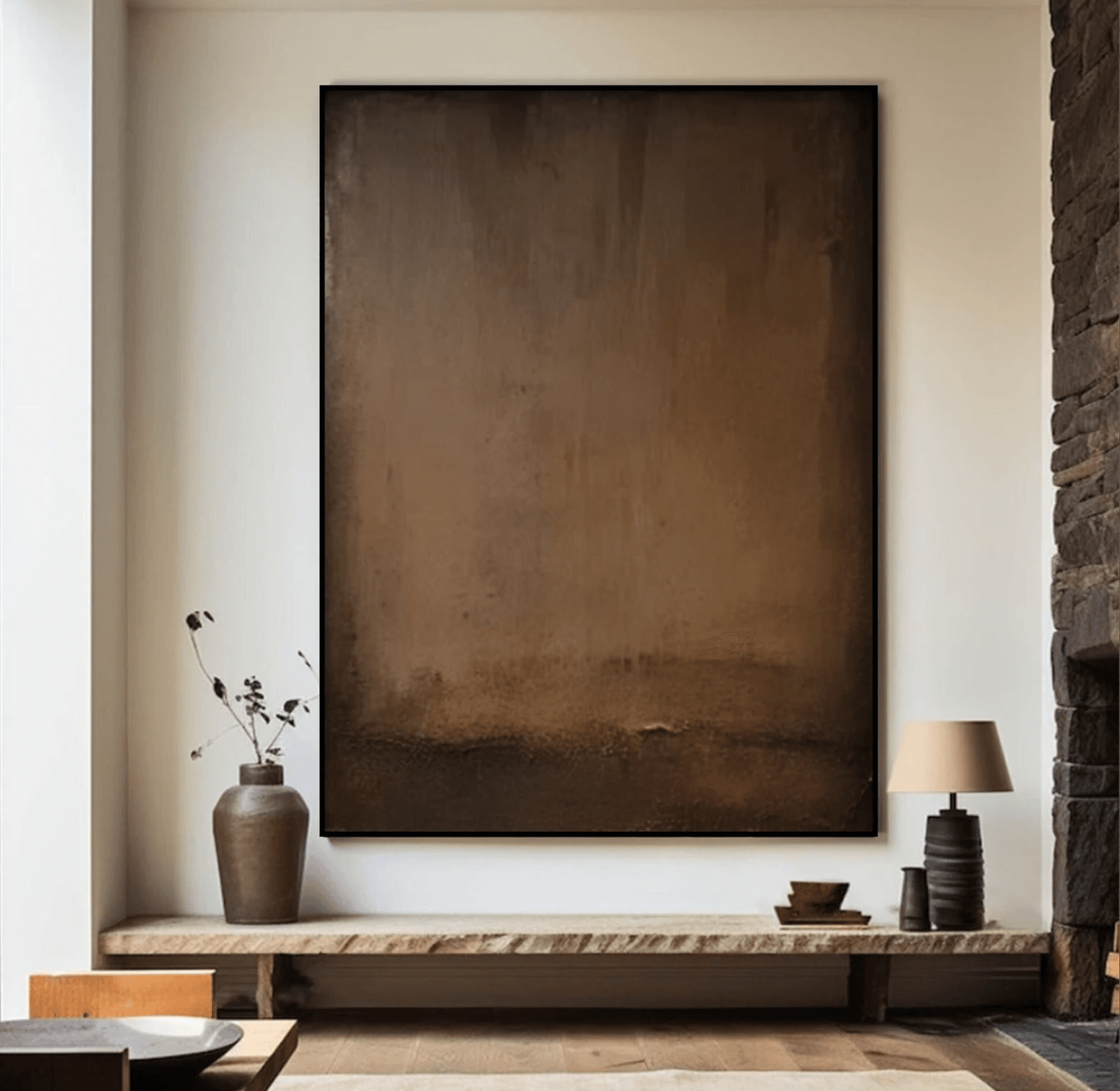 A large piece of neutral brown artwork hangs above a long wooden bench as an entryway wall art idea 